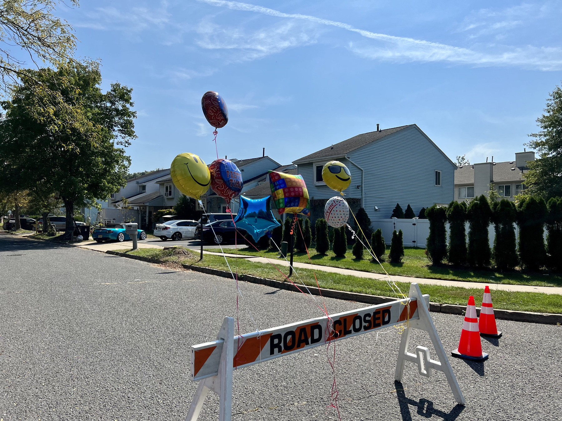 Road closed sign with balloons attached to advertise a party